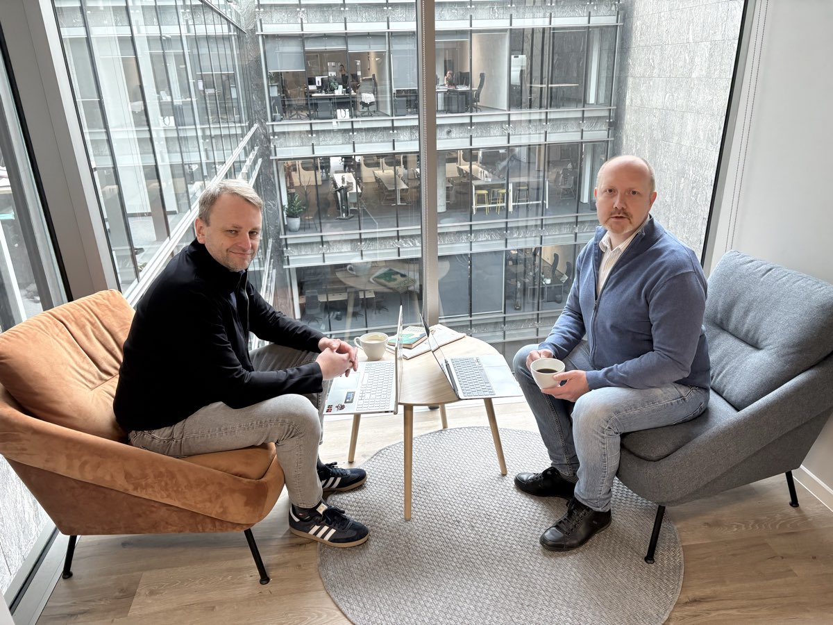 Optiveum team members discussing over coffee in the office
