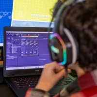 a video engineer with headphones in front of a laptop